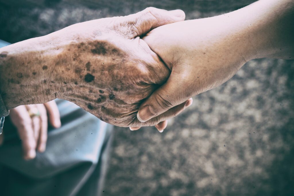 An elderly person with a younger caregiver