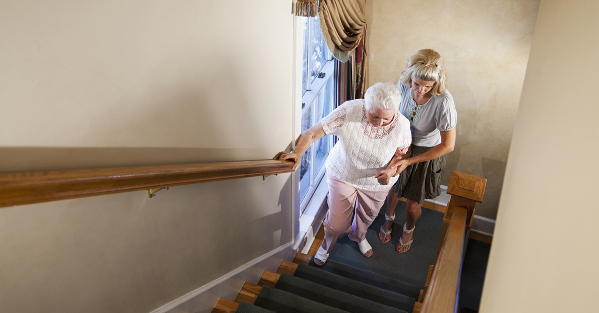 Woman helping grandma up stairs