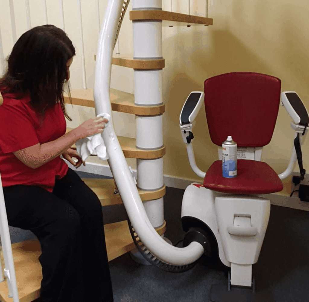 woman dusting stairlift rail