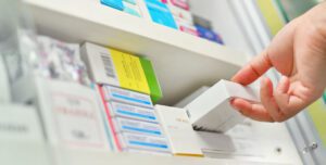 Pharmacist pulling medication from shelf